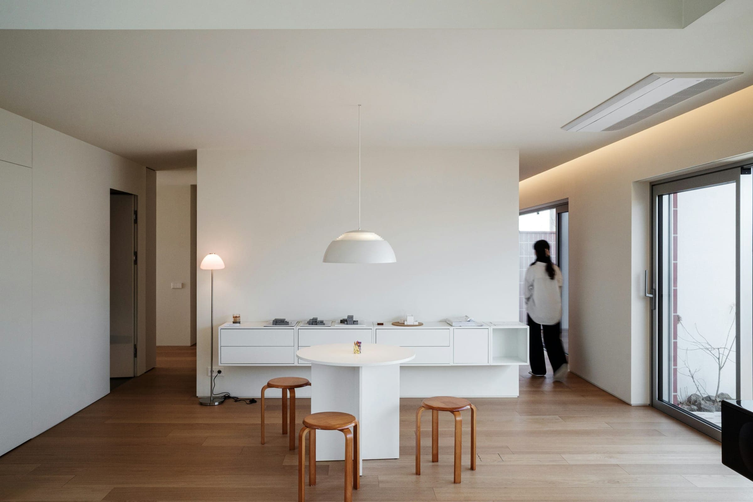 A calm, minimalist interior with smoothly finished walls and warm wood floors.